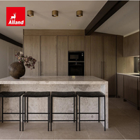 Meuble de cuisine Alland au design moderne, texture chêne mat, lignes épurées, avec îlot de cuisine en pierre chaude effet cascade pour la rénovation résidentielle