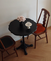 Table de bistrot vintage de style parisien, plateau rond en bois festonné avec base en fonte.