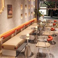 Ensemble de table et de chaises de café en métal moderne avec coussins orange et éclairage chaleureux pour les cafés et bars élégants