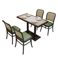 Ensemble de table et chaises de restaurant et bistro moderne avec dossier en rotin tressé et structure en métal, table avec plateau en pierre pour la salle à manger