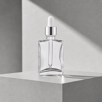 Flacon compte-gouttes carré en verre transparent de qualité supérieure 1 oz avec collier argenté pour le traitement du visage et l'emballage d'huiles essentielles