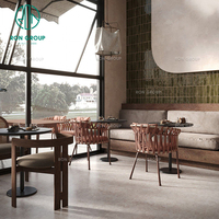 Ensemble de mobilier de café Wabi-Sibi : table ronde en pierre frittée, chaise en rotin, banquette rembourrée