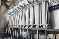 Ligne de remplissage, bouchage, étiquetage et emballage de liquides visqueux pour détergent à lessive avec système de remplissage linéaire servo-contrôlé