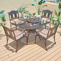 ronde de foyer de barbecue coulé dans le jardin d'un hôtel mobilier d'extérieur ensemble table à manger et chaises en aluminium