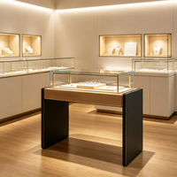 Vitrine à bijoux moderne et élégante avec dessus en bois clair, panneau latéral foncé, armoire en verre transparent avec éclairage LED chaud intégré pour la vente au détail de bijoux