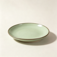 Collection de vaisselle en poterie verte rustique élégante EKA, assiettes et bols en céramique au look artisanal avec bord infusé de fer