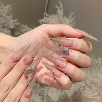 Ongles artificiels de luxe faits à la main, couleur rose nude transparente, style stiletto, avec dégradé de paillettes fines et strass multi-tailles dispersés