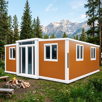Maison pliable modulaire à ossature blanche et panneaux ondulés orange, avec double porte vitrée, pour villa de villégiature en bord de mer, construction rapide
