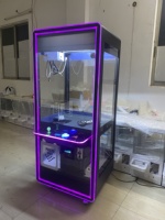Machine à griffes à monnayeur avec cadre LED néon, vitrine en verre, commande par joystick et fente pour les prix, pour utilisation en boutique de cadeaux dans un centre commercial
