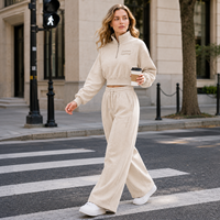 Conjunto de dos piezas al por mayor para mujer: Sudadera corta de algodón polar color marfil con cremallera de un cuarto y pantalón de chándal de cintura alta de pierna ancha estilo streetwear.