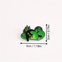 Épingle en émail de créature de forêt enchanteresse-Figure noire parmi les feuilles vertes. Un accessoire fantaisiste pour les amoureux de la nature