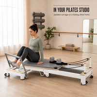 Reformer Pilates avec cadre en bois et coussinets gris pour l'entraînement et les étirements du tronc en studio