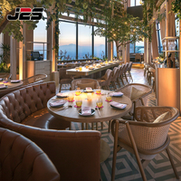 Ensemble de mobilier de restaurant commercial J2S avec banquette en cuir marron, table ronde et chaises en rotin pour projets hôteliers