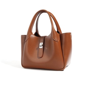 Una borsa in pelle semplice e di nicchia tenuta in mano da donna con un Design grande ed elegante è una borsa A tracolla a spalla singola e sotto le ascelle - Product Image 3