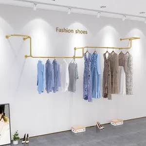 玫瑰金金属壁衣服吊轨展示架的精品服装店