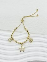 Bracelet tendance en cuivre plaqué or avec breloques papillon, croix et mini breloques émaillées, perles en verre transparent, vente en gros