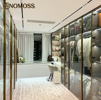 Dressing moderne de luxe avec aménagement de rangement personnalisé et système d'armoires à portes vitrées haut de gamme pour projets d'aménagement intérieur de villas