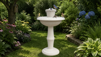 Fontaine sur piédestal classique blanche avec bassin à niveaux, pulvérisateur en forme de couronne, base ornée en relief et décoration aquatique pour jardin extérieur