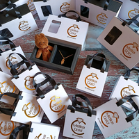 Boîte cadeau de luxe blanche pour bijoux, personnalisée avec estampage à chaud doré et ruban satiné, idéale pour les bijouteries.