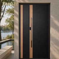 Porte d'entrée de sécurité en acier finition grain de bois noir avec garniture en bois clair et poignée intégrée pour villa privée