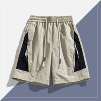 Short coupe-vent personnalisé unisexe doublure en maille de nylon à séchage rapide fermeture à cordon taille moyenne style décontracté poches à motif chaud