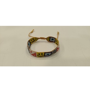 Bracelet artisanal Sstringz en perles Miyuki Delica multicolores avec motif visage souriant jaune, motif œil bleu et motif à carreaux noir et blanc - Product Image 1