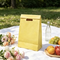 Sacs en papier kraft jaune personnalisables avec design à enroulement, poignées découpées et fond renforcé pour l'emballage alimentaire