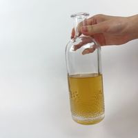 Bouteille d'alcool ronde en verre à bouche plate avec gaufrage gravé