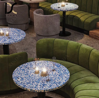 Canapé banquette capitonné en velours vert à cannelures courbes, table ronde à plateau en terrazzo bleu pour restaurant, bar à vin ou lounge aux tons sombres