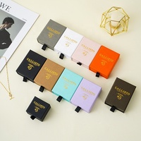 Boîte de rangement pour bijoux A1, collection sélectionnée, avec intérieur noir, logo doré et poignée frontale pour une présentation en boutique