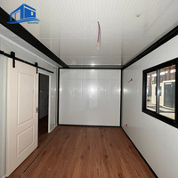 Maison-conteneur extensible de 40 pieds Bâtiments à structure en acier Chambre à coucher avec cadre noir, mur ancien, motif en bois de chêne gris,