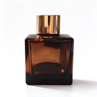 Flacon diffuseur de parfum carré de luxe de 50 ml, disponible en transparent et ambre, avec bouchons et bouchons intérieurs dorés et argentés.