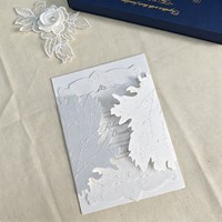 Suite d'invitations de mariage florales blanches haut de gamme avec détails en relief, cartes découpées, ruban, enveloppe et sceau de cire pour mariages de boutique
