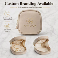 Étui de voyage beige pour bijoux avec fermeture éclair, anneau de traction à pompon et poche intérieure