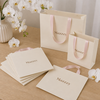 Sacs en papier mat laminé personnalisés avec poignées en ruban et impression de logo, vente en gros pour les magasins de vêtements