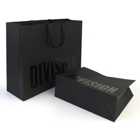Sac en papier couché recyclable de luxe noir et or personnalisé avec poignée en ruban et pelliculage pour l'emballage de vêtements