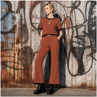 Ensemble tricoté côtelé style rétro années 70 pour femme : haut à manches courtes avec passepoil contrastant et pantalon évasé taille haute pour un look tendance