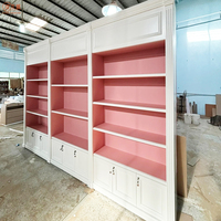 Magasin de vêtements de luxe haut de gamme présente des présentoirs de sacs en bois massif rose et blanc sur mesure, meubles de boutique