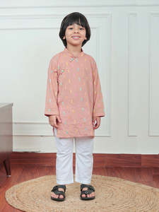 Lindo niño pequeño con kurta color melocotón con estampado colorido y pijama blanco, sonriendo en el interior con un atuendo festivo tradicional. - Product Image 2