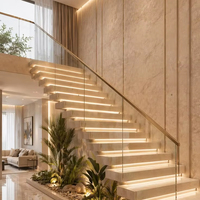 Escalier intérieur courbé avec bande lumineuse LED et main courante en verre pour résidence