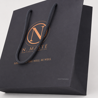 Sac shopping en papier noir mat de luxe avec poignée en corde, logo en feuille d'argent bronze, sac de transport en papier personnalisé