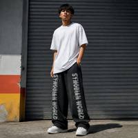 Pantalon de survêtement ample personnalisé à jambe large, en molleton, avec ourlet brut et effet usé, imprimé SYNOBIAN WORLD, style streetwear, vente en gros JUSHENG