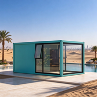 Maison en verre moderne, préfabriquée, modulaire, avec structure en acier, fenêtre à auvent et porte solide, idéale pour jardin, villa, complexe hôtelier ou gîte.