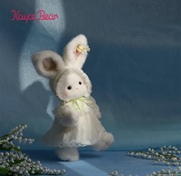 Adorable lapin en peluche blanc sur le thème du printemps avec robe en dentelle et tulipe