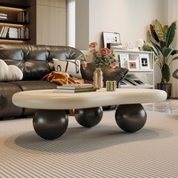 Table basse élégante et luxueuse de style nordique minimaliste, mini, unique, couleur crème, avec base en boule noire