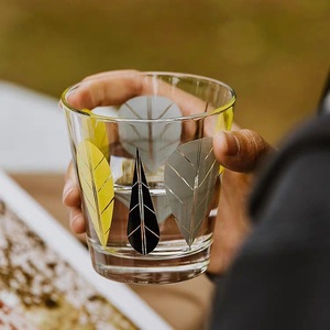 Tasse en verre transparente au design élégant de feuilles jaunes et grises, parfaite pour la maison et les cafés - Product Image 1