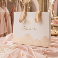 Sac cadeau personnalisé en papier blanc pour lingerie avec logo imprimé et nœud en dentelle dorée, poignée en ruban de satin, emballage de vente au détail pour boutique de lingerie