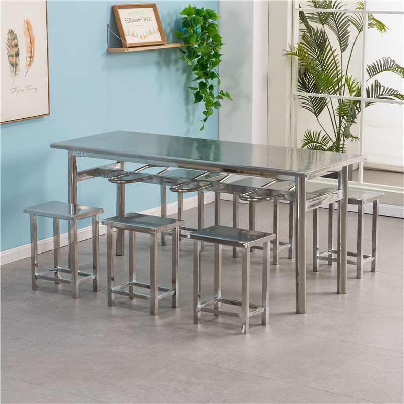 Mesa de acero inoxidable con 6 taburetes.
