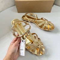 Sandales plates dorées métallisées à nœuds et lanières multiples fines pour femme, avec bride de cheville à boucle, idéales pour l'été, la plage et les soirées habillées