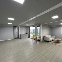 Maison conteneur extensible préfabriquée, unité de villa rectangulaire avec mur beige, cadre noir et double porte vitrée